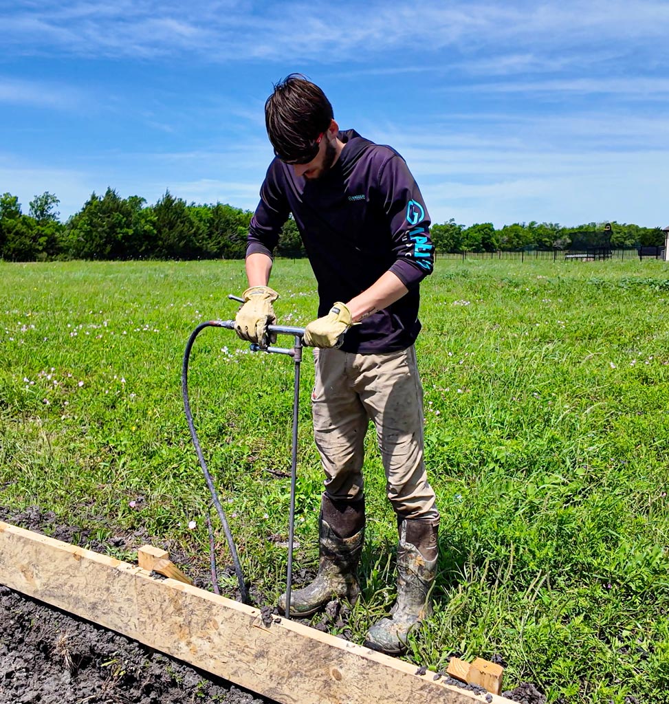 STX90 technician performing hand injection soil stabilization on a residential build site in Texas